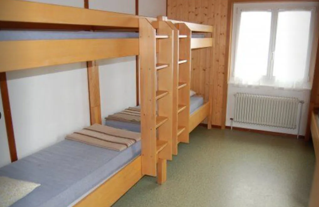 Une chambre de 5 lits avec lits superposés en bois