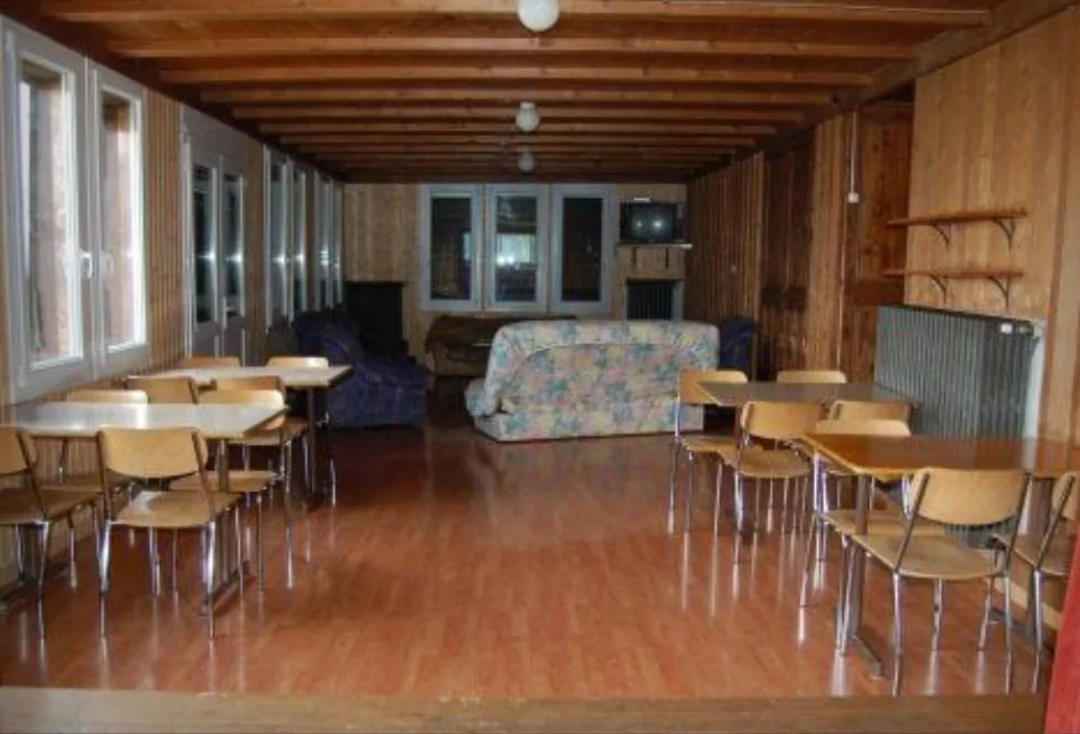 Grande salle TV boisée avec canapés et tables