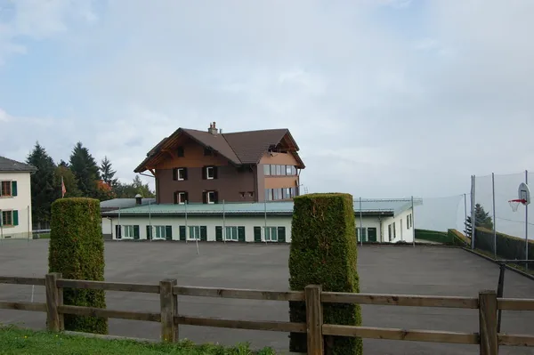 Le terrain de jeux grillagé devant le chalet