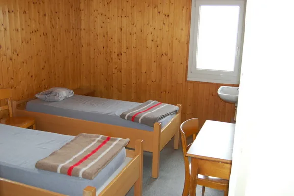 Chambre de deux lits lambrissée de bois
