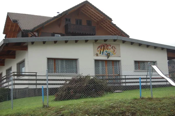 L'entrée du chalet avec l'enseigne colorée Arc-en-Ciel