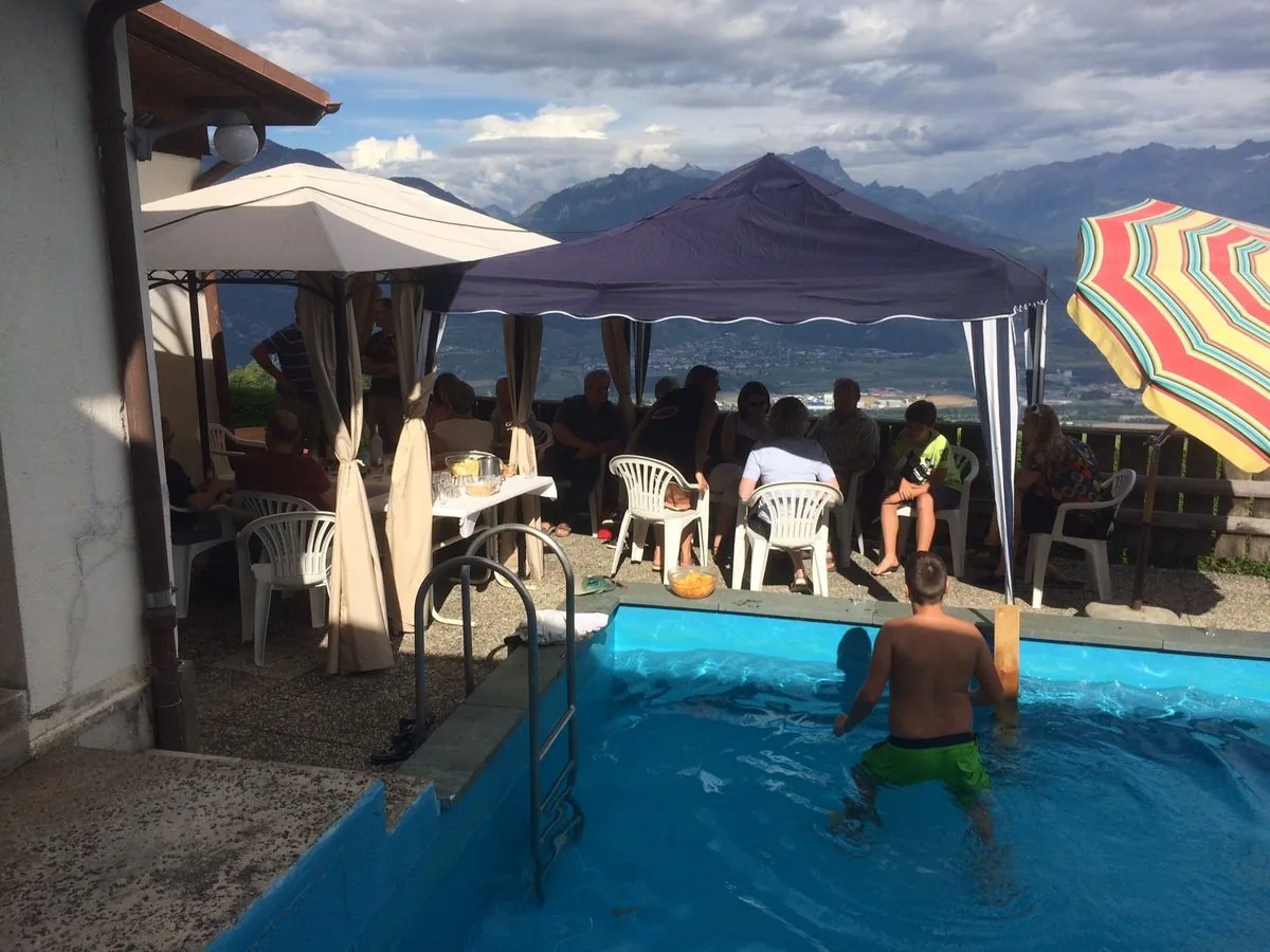 Un groupe sur la terrasse au bord de la piscine, vue sur la plaine du Rhône